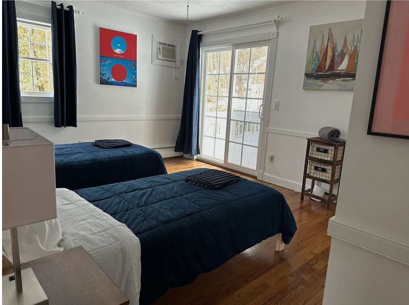 A shared bedroom with two twin beds and a sliding door to the deck.